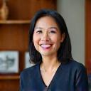 Professional portrait of an empathetic Filipino HR director, Elena Santos, with a warm, modern office environment in the background.